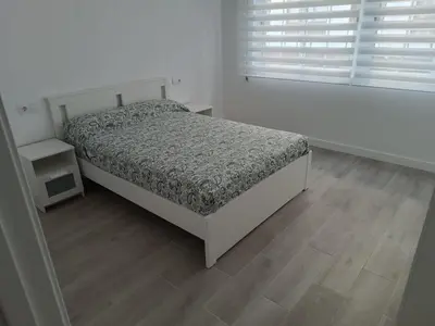 a white bedroom with a bed and a window at Vivienda Ares Centro in Ares