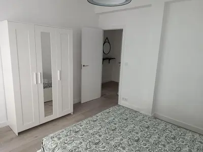 a white bedroom with white cabinets and a rug at Vivienda Ares Centro in Ares