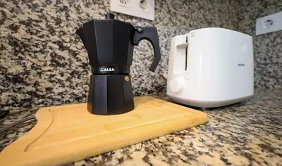 a black coffee maker on a counter next to a toaster at YourHouse Casa Antonio in Amoeiro