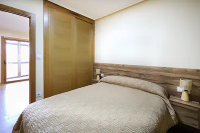 a bedroom with a bed and a wooden wall at YourHouse Casa Antonio in Amoeiro