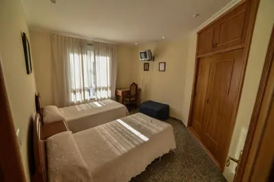 a bedroom with two beds and a wooden door at Casa Palomin