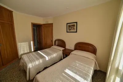 a bedroom with two beds and a window at Casa Palomin