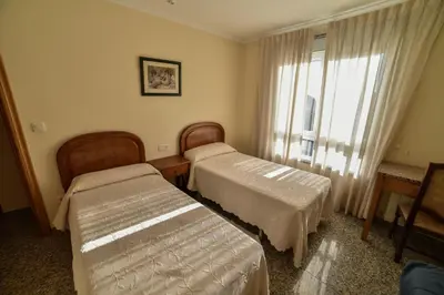 a hotel room with two beds and a window at Casa Palomin