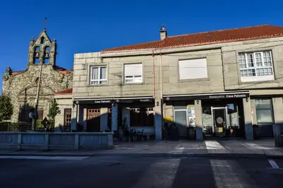 an old building with a clock tower and a church at Casa Palomin