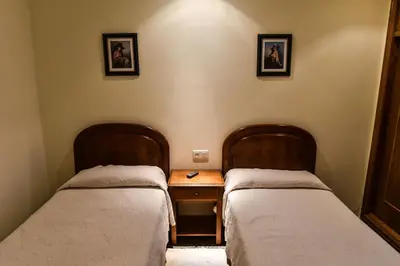 two beds in a room with a wooden table at Casa Palomin