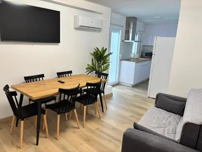 a living room with a wooden table and chairs at Casa do práctico in Foz