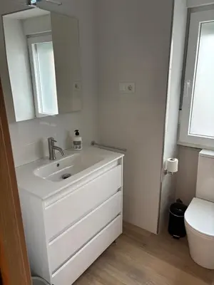 a white bathroom with a sink and a toilet at Casa do práctico in Foz