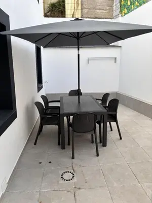 a black table and chairs with an umbrella on a patio at Casa do práctico in Foz