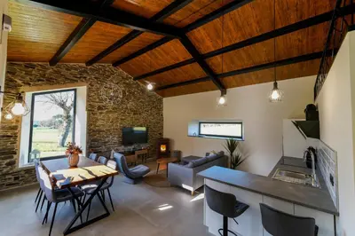 a kitchen and living room with a stone wall at Casa Rural Lugar Vista Alegre in Lugo