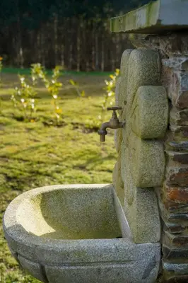a stone fountain with a sink on a stone wall at Casa Rural Lugar Vista Alegre in Lugo