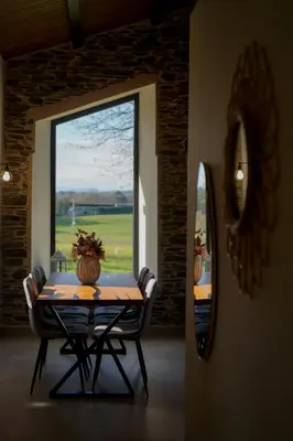 a table and chairs in a room with a large window at Casa Rural Lugar Vista Alegre in Lugo