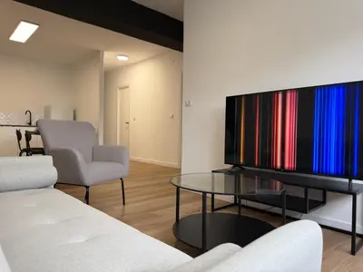 a living room with a tv and two chairs and a table at Apartamento Padrón Centro, A de Marcelino by URent in Padrón