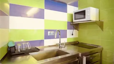 a kitchen with a sink and a microwave at Albergue Ezequiel in Melide