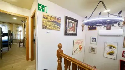 a hallway with a staircase with a blue ceiling at Albergue Ezequiel in Melide