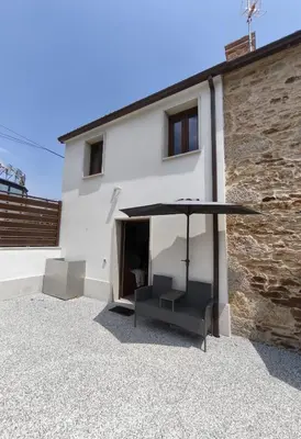 a patio with two chairs and an umbrella in front of a building at Casa Aradas in Santiago de Compostela