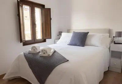 a bedroom with a white bed with towels on it at Casa Aradas in Santiago de Compostela