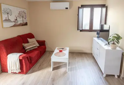 a living room with a red couch and a table at Casa Aradas in Santiago de Compostela