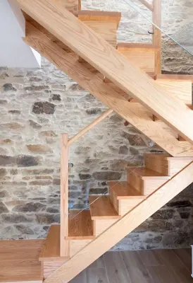 a wooden staircase in a house with a stone wall at Casa Aradas in Santiago de Compostela