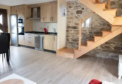 a kitchen with wooden cabinets and a wooden staircase at Casa Aradas in Santiago de Compostela