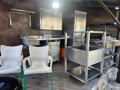 a kitchen with two white chairs and a counter at Casita con encanto in Mondariz