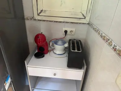 a small white cabinet with a red appliance on it at Casita con encanto in Mondariz