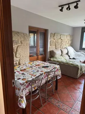 a living room with a table and a couch at Casita con encanto in Mondariz
