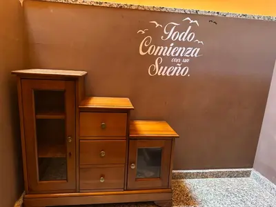 a wooden cabinet against a wall with a sign on it at Casita con encanto in Mondariz