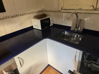 a small kitchen with a sink and a microwave at Casita con encanto in Mondariz
