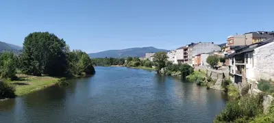 a river in a city with houses and buildings at A CASONA DO BARCO con garaje privado, jardín y buenas vistas in O Barco de Valdeorras
