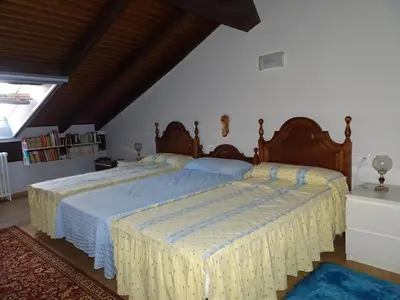 a bedroom with two beds with blue and yellow sheets at A CASONA DO BARCO con garaje privado, jardín y buenas vistas in O Barco de Valdeorras