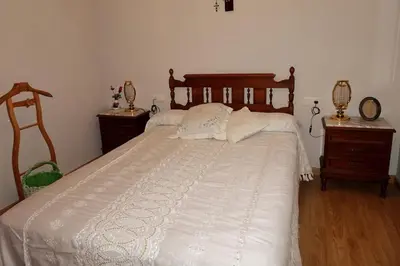 a bedroom with a large white bed with two night stands at A CASONA DO BARCO con garaje privado, jardín y buenas vistas in O Barco de Valdeorras