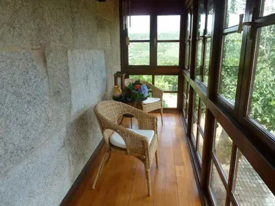 a room with a chair and a table and windows at Holiday Home mit Privatpool by Interhome in Parada del Sil
