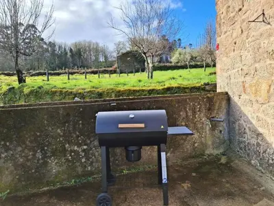 a barbecue grill sitting next to a stone wall at Holiday Home Galicia Retreat by Interhome in Cerdedo