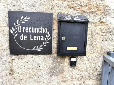 a black mailbox on a stone wall with a sign at Holiday Home Galicia Retreat by Interhome in Cerdedo