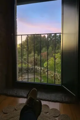 a person standing in a room looking out of a window at Holiday Home Galicia Retreat by Interhome in Cerdedo