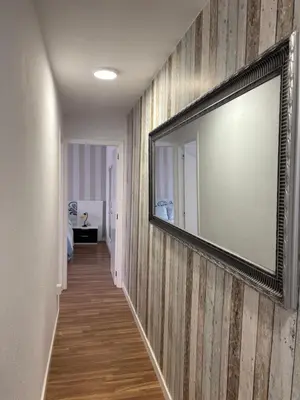 a hallway with a mirror on a striped wall at Torkes in Foz