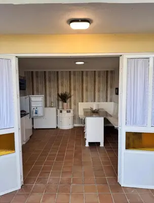 a kitchen with white appliances and a table in it at Torkes in Foz