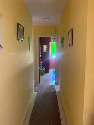 a hallway with yellow walls and a door with a green light at Barreiros in Barreiros
