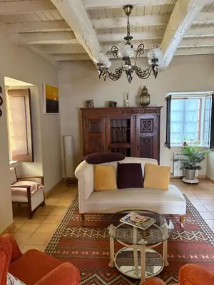 a living room with a couch and a chandelier at Casa de la fuente de Vista Alegre in Sarria