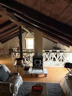 a living room with a stove in the middle at Casa de la fuente de Vista Alegre in Sarria