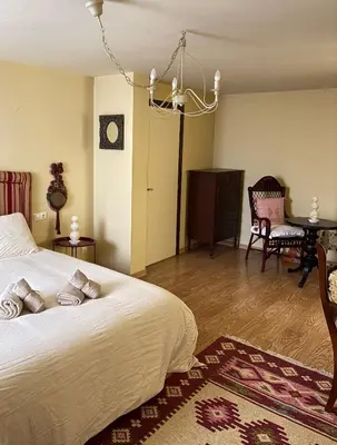 a bedroom with a bed and a table and chairs at Casa de la fuente de Vista Alegre in Sarria