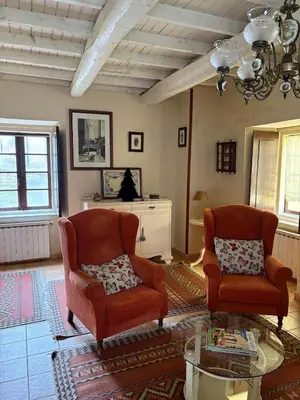 a living room with two chairs and a table at Casa de la fuente de Vista Alegre in Sarria