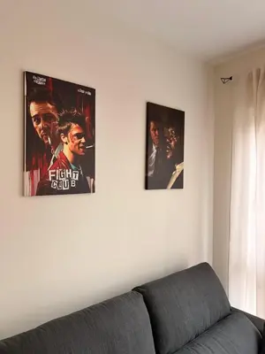 two movie posters on a wall above a couch at Milagrosa Square in Lugo