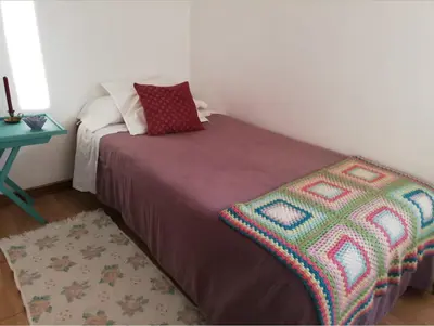 a bedroom with a bed with a blanket and a table at Casa Salvia