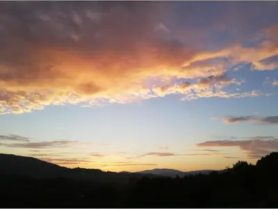 a sunset in the sky over a mountain at Casa Salvia