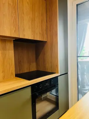 a kitchen with a black oven and wooden cabinets at Apartamento Moderno en el Centro !-CheckHostProfile-! in Lugo