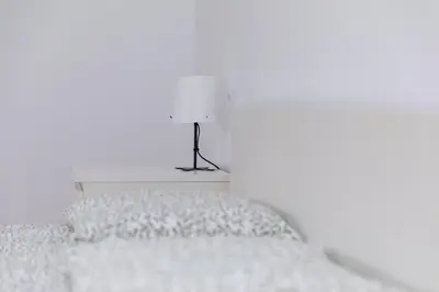 a white bedroom with a bed with a lamp on it at Apartamento dentro de la Muralla de Lugo, Rúa Nova in Lugo