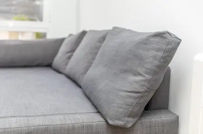 a gray couch with a pillow on it at Apartamento dentro de la Muralla de Lugo, Rúa Nova in Lugo