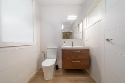 a white bathroom with a toilet and a sink at Apartamento dentro de la Muralla de Lugo, Rúa Nova in Lugo