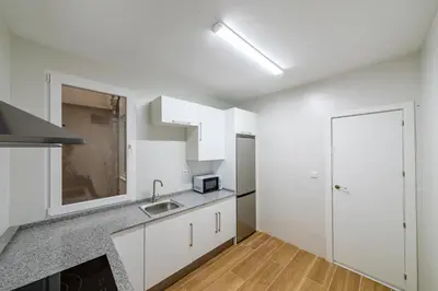 a kitchen with white cabinets and a sink at Apartamento dentro de la Muralla de Lugo, Rúa Nova in Lugo